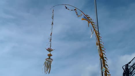 balinese hindu penjor decorative bamboo pole with offerings to ancestral spirits on galungan festival in bali indonesia