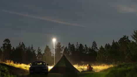 a family is camping in the dim lit norwegian forest landscape