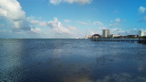 Sobrevuelo-Aéreo-De-Drones-Escénico-Océano-Azul-Con-Una-Mujer-Caminando-Por-La-Costa-Rocosa,-Cancún-México-4k