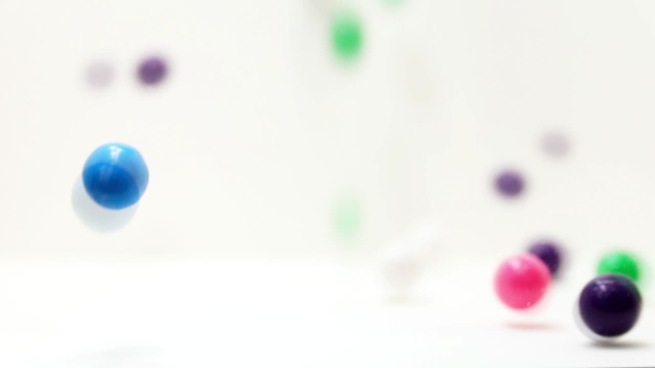 Forward Slow Motion of Gumballs bouncing and tumbling into frame