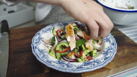 chef plating a salad on table in home kitchen