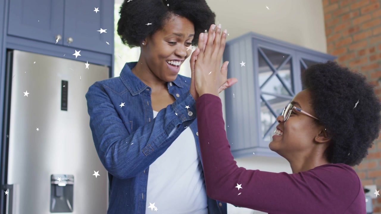 Mother leaning over pointing at homework, helping daughter in kitchen, stars sparkling, high-fiving