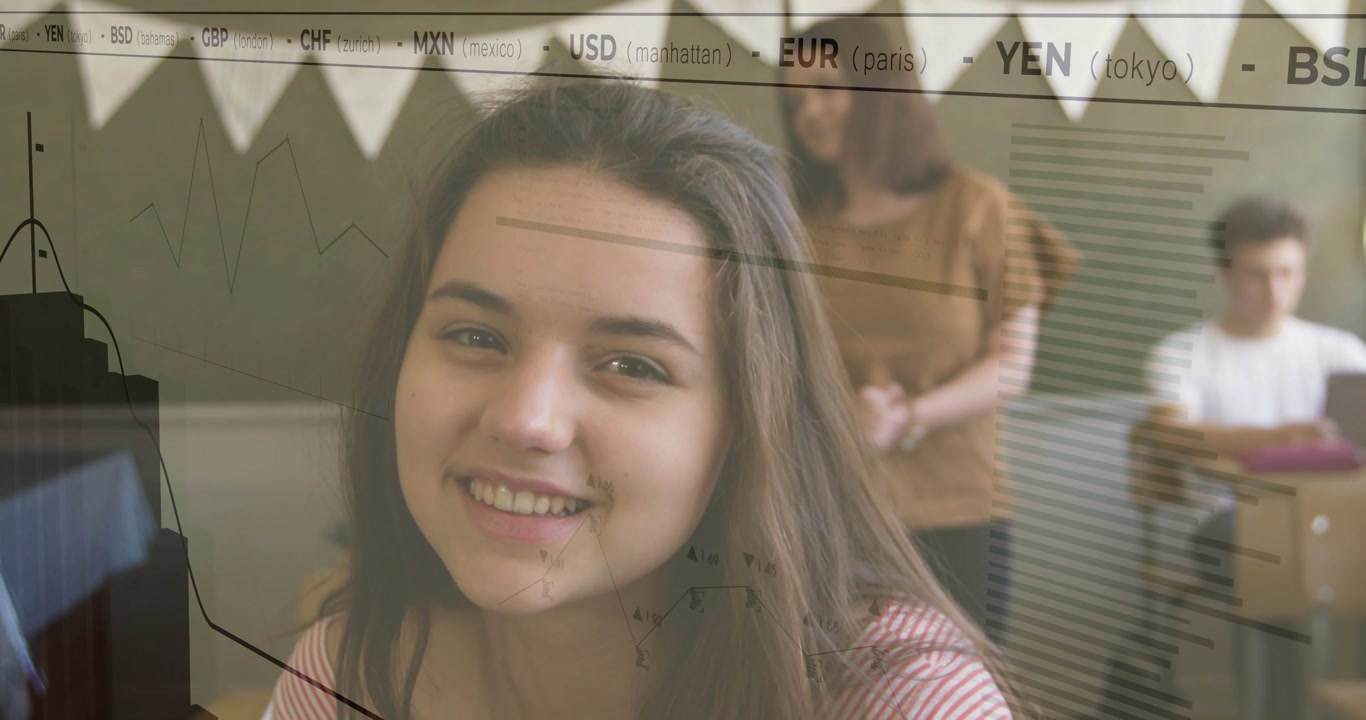 Teenage girl smiling in classroom, teacher observing, boy using laptop with animated finance charts