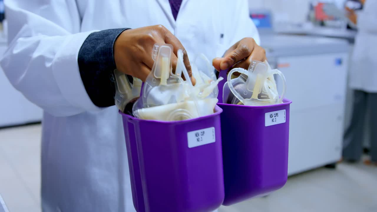 Laboratory technician carrying blood bags 4k