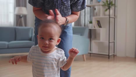 Father Encouraging Smiling Baby Son Walk At Home