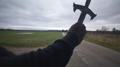 Guerrero-Espadachín-Negro-Moderno-Esperando-Oponente-De-Batalla-En-Campo-Abierto-Bajo-Un-Cielo-Gris,-Europa,-4k-|-Musculoso,-Intimidante,-Sombra,-Figura,-Borrosa,-Ropa-Oscura,-Poderoso,-Esperando,-Tocando-El-Dedo