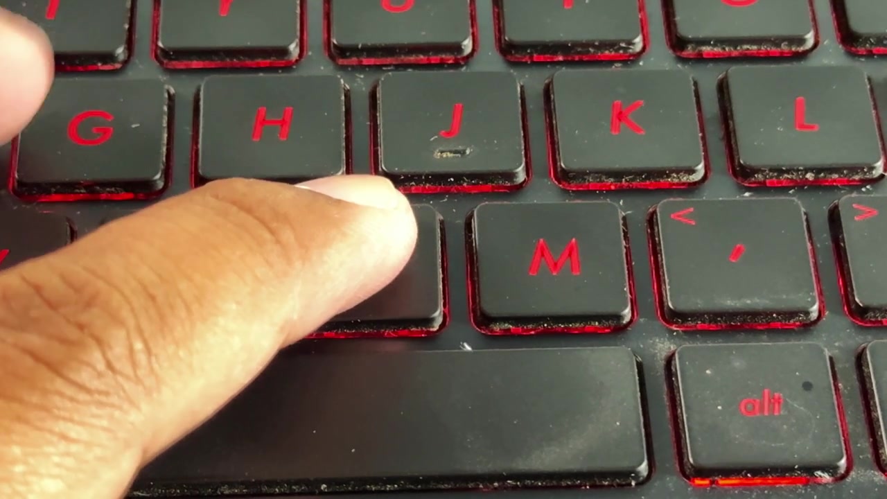 Human hand interacting with laptop keyboard on "N" button, emphasizing modern computing and online communication.