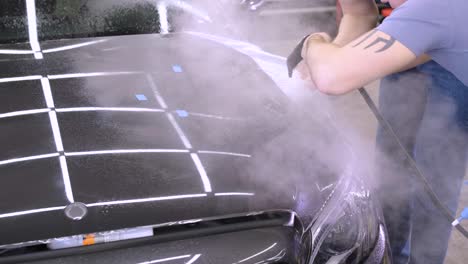 hombre que cubre el coche con cinta de poliuretano de vinilo. películas para el coche. pegatina película protectora en el coche