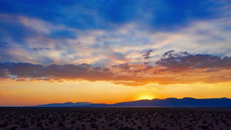 hiperlapso de puesta de sol mientras se mueve rápidamente a lo largo del paisaje desértico mientras el sol se pone más allá de la lejana cordillera