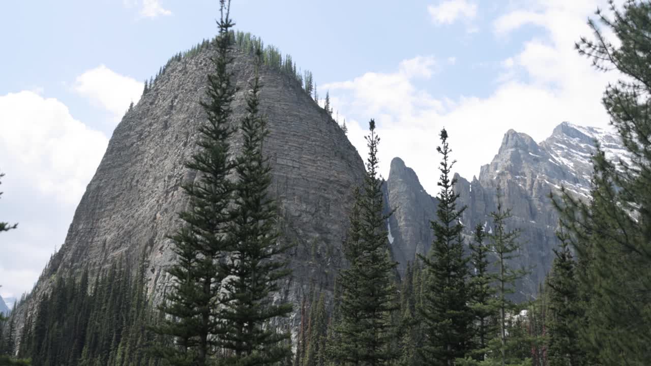 Beautiful view of a rocky mountain top from the hiking trail up to Lake Agnes Tea House on Mount St. Piran and Mount Whyte, within Banff National Park near Lake Louise Alberta.