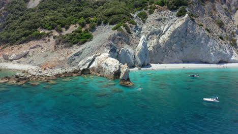 aerial: slow orbit shot of the limestone arch rock formation in lalaria beach in skiathos island, sporades, greece on a sunny day