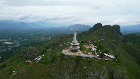 Aerial-of-a-Jesus-Christ-Statue-in-Tana-Toraja-Sulawesi-at-the-top-of-a-mountain-with-tourists-and-shops