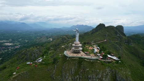 antena de una estatua de jesucristo en tana toraja sulawesi en la cima de una montaña con turistas y tiendas
