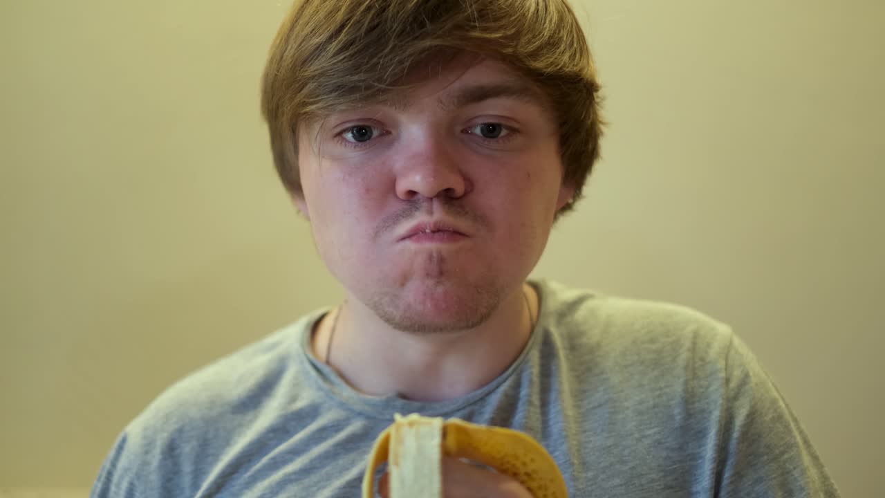 Ung mand spiser en sandwich
