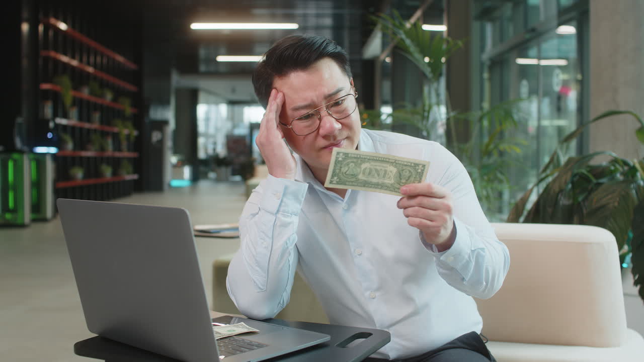 Upset businessman feeling worried about financial problems bad day sitting in modern office lobby