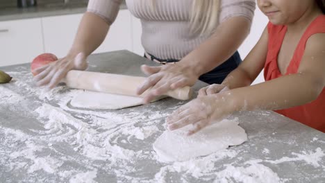 de las manos de la madre y la hija pequeña horneando juntos