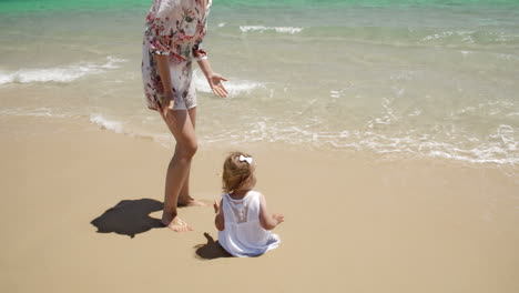 Mamá-Cuidando-A-Su-Niña-Disfrutando-En-La-Playa