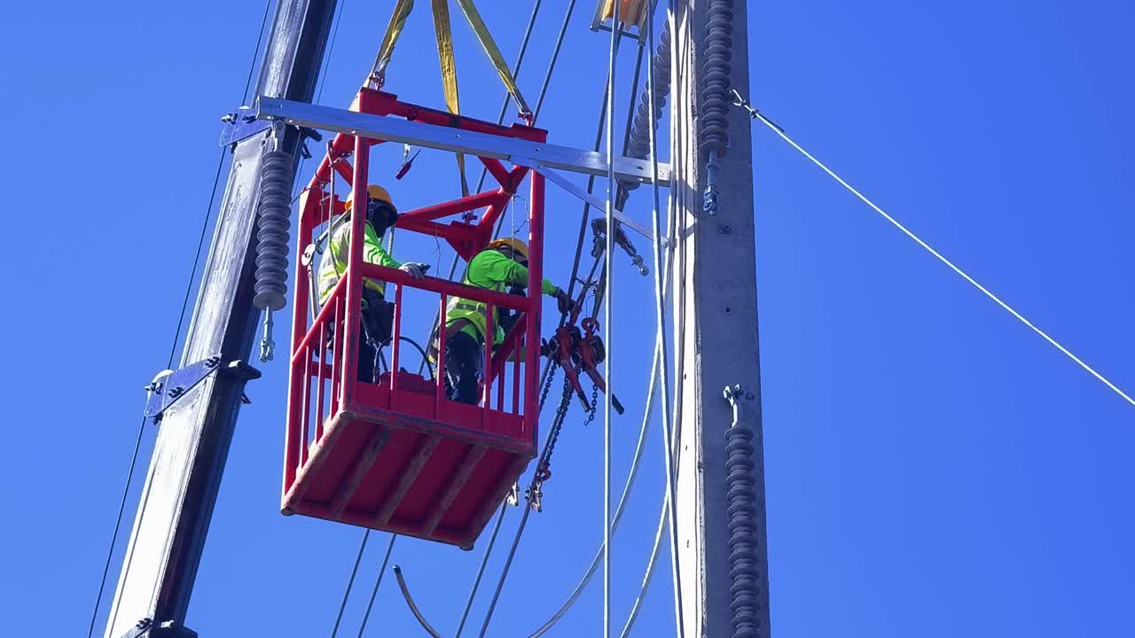 trabajadores de líneas eléctricas trabajando en un poste de energía