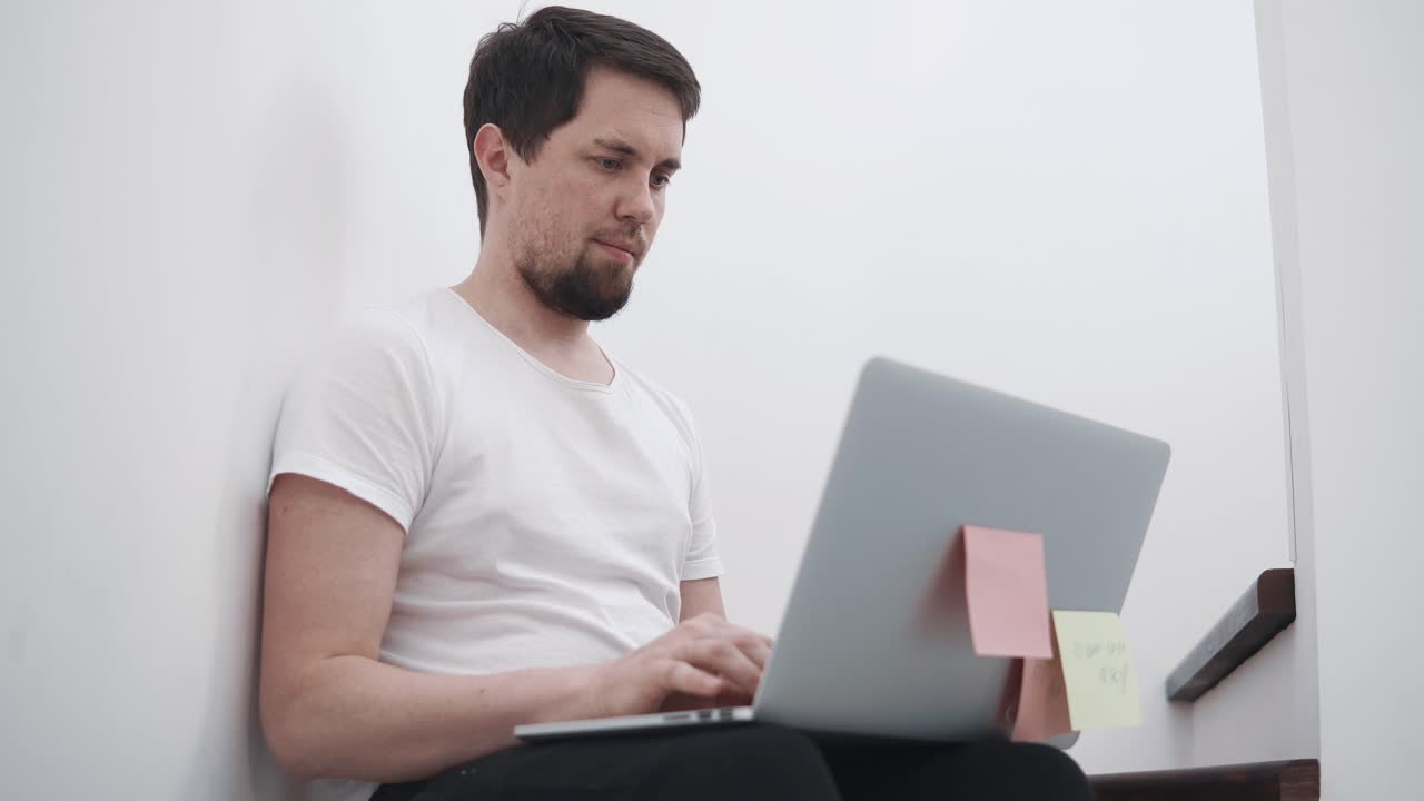 계단에서 노트북으로 일하는 남자