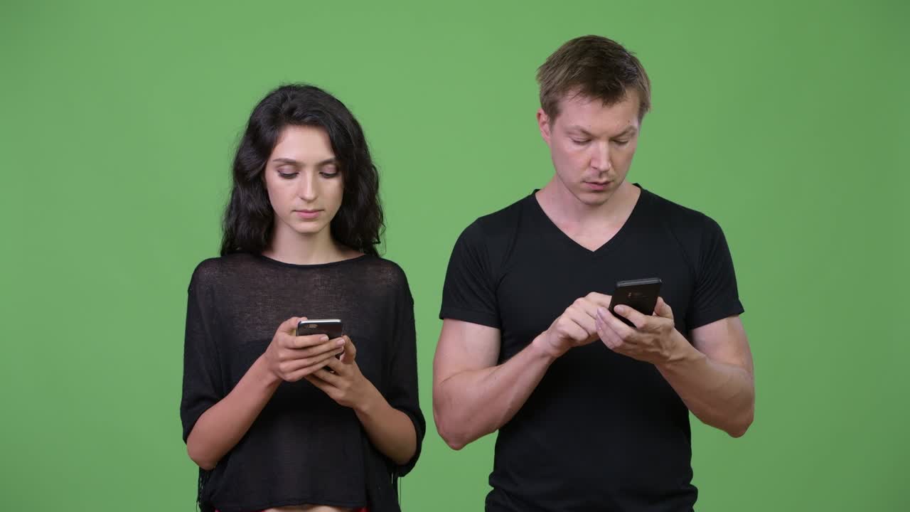 una pareja joven usando el teléfono juntos.