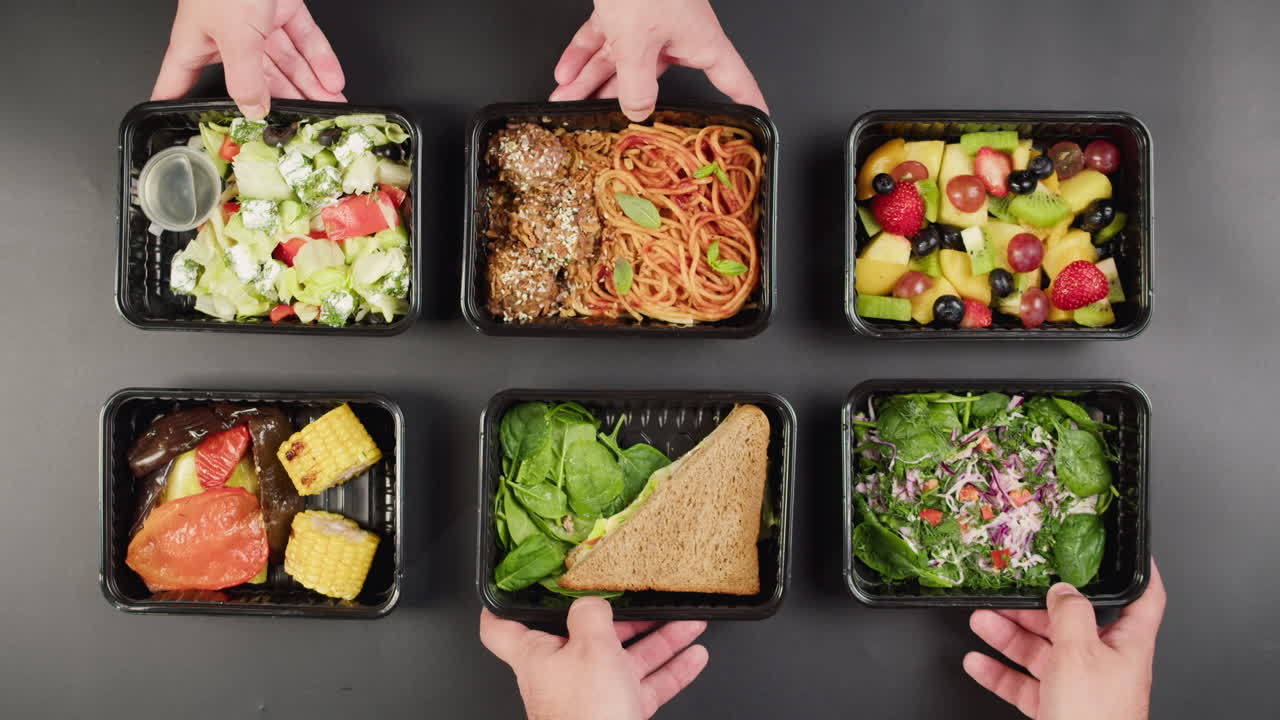 Top View of Hands Arranging Healthy Meal Prep Food Containers