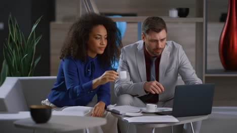 Multiethnic-corporate-couple-working-laptop-computer-in-cafe-workplace-office.