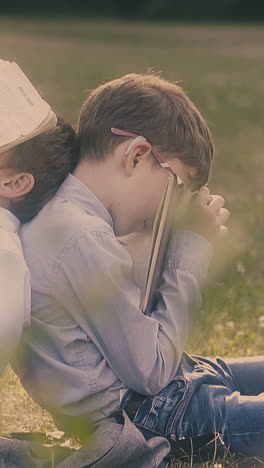 strong wind waves book pages on sleeping pupil head with pen in mouth sitting near schoolboy in glasses slow motion
