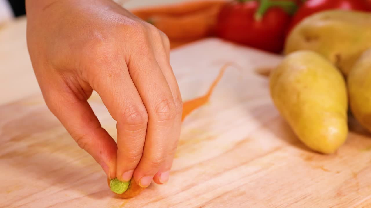 손은 근처에 감자와 함께 당근을 고 있습니다.