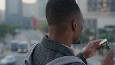 Retrato-Atractivo-Joven-Afroamericano-Usando-Un-Teléfono-Inteligente-Tomando-Fotos-De-Una-Ciudad-Ocupada-Al-Atardecer-En-La-Tecnología-De-La-Cámara-Del-Teléfono-Móvil-En-Cámara-Lenta