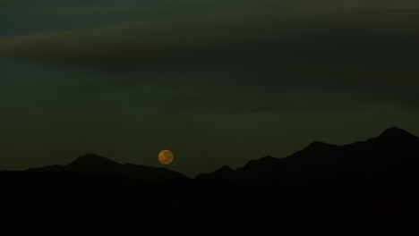 imágenes de la superluna poniéndose sobre las colinas durante la madrugada