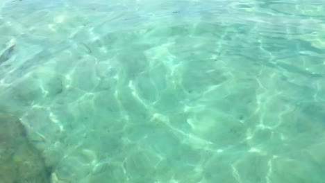 cámara lenta de la superficie de agua de mar transparente, translúcida y transparente con suelo de arena blanca y ondas