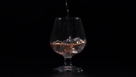 filling glass with drink on the rocks slow motion 4k