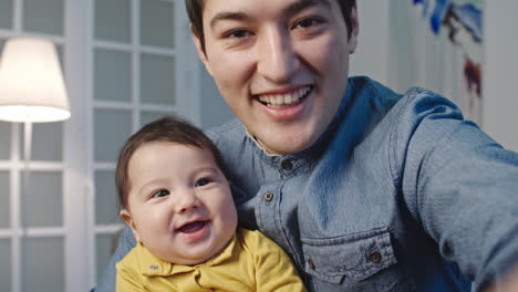 Happy-Father-Holds-His-Little-Baby-While-Making-A-Video-Call