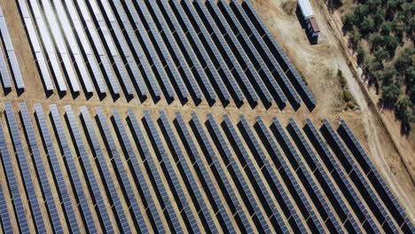 aerial view of big solar panels array, solar power planet by olive plantation in countryside of spain