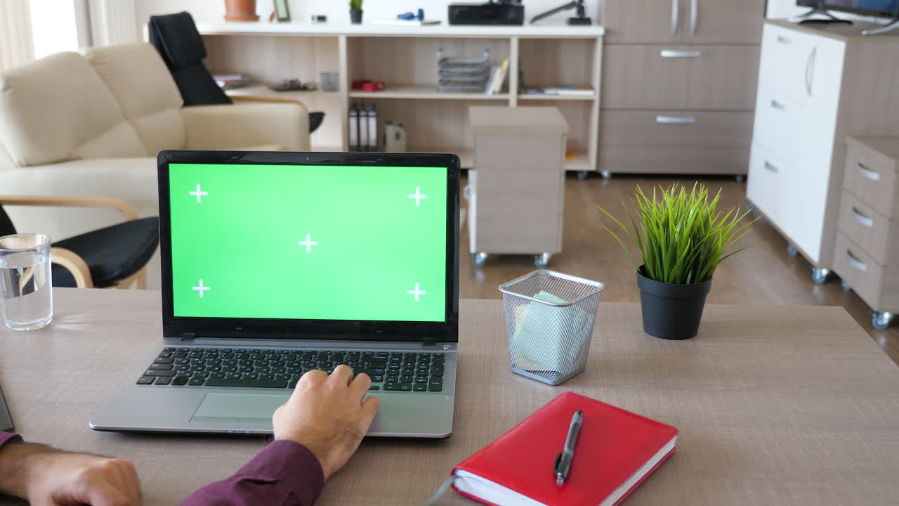 persona que trabaja en una computadora portátil con pantalla verde