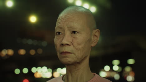 old asian woman in city at night