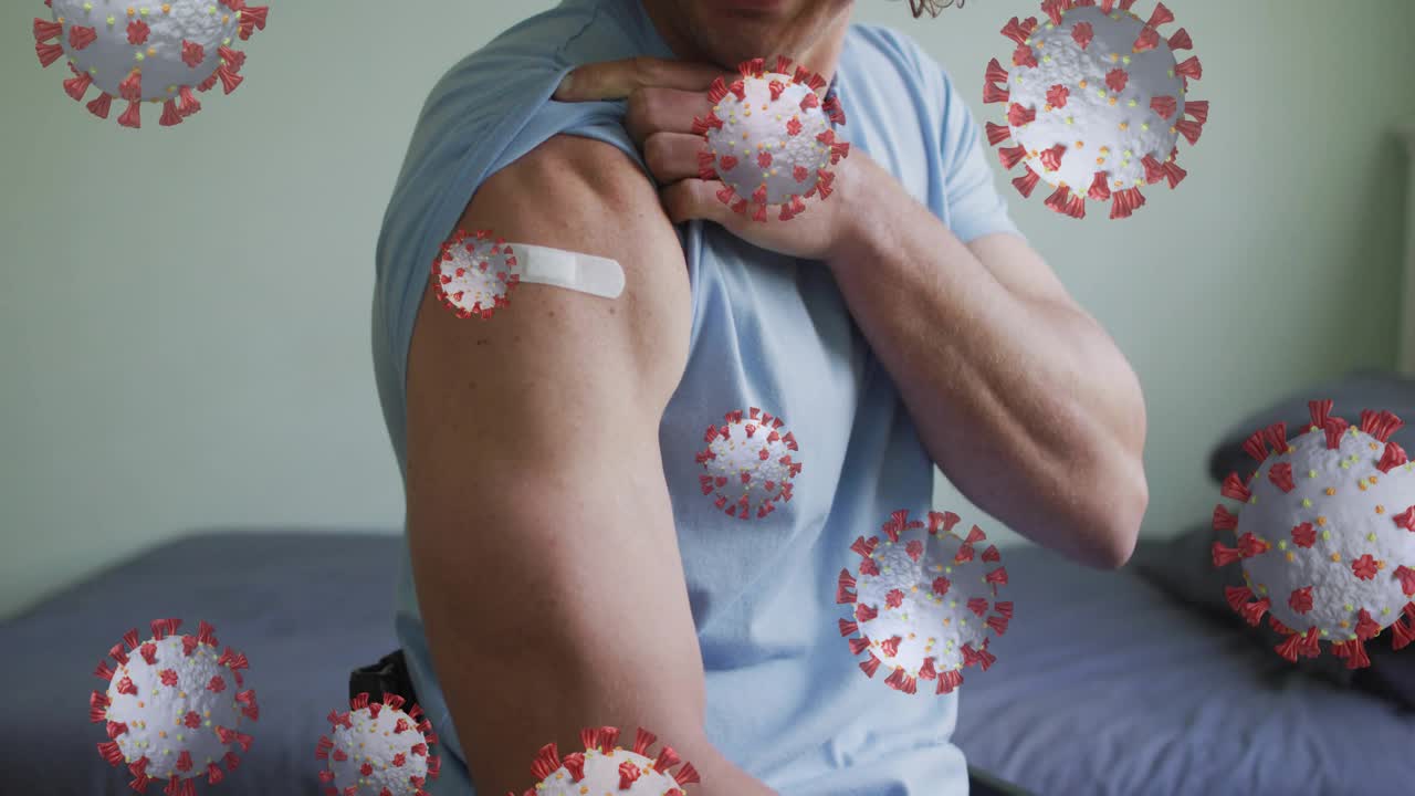Man pulling up sleeve and showing bandage, virus icons growing over arm, highlighting vaccination