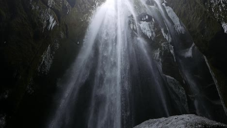 Una-Alta-Cascada-Que-Cae-En-Una-Caverna-Con-Carámbanos-En-Las-Paredes