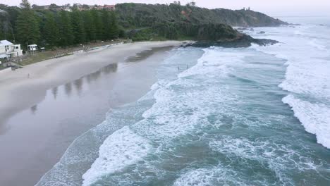 Luftrückwärtsschwenk-Bei-Sonnenaufgang-Am-Strand-Von-Port-Macquarie-Mit-Nicht-Erkennbaren-Menschen