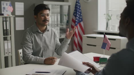 indian man answering questions during us visa interview at embassy