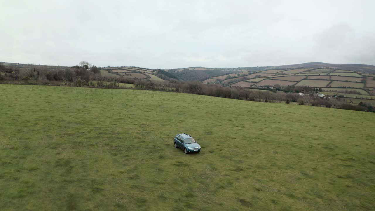 빈 들판에서 4x4를 운전하는 농부의 돌리 백 공중 드론 샷