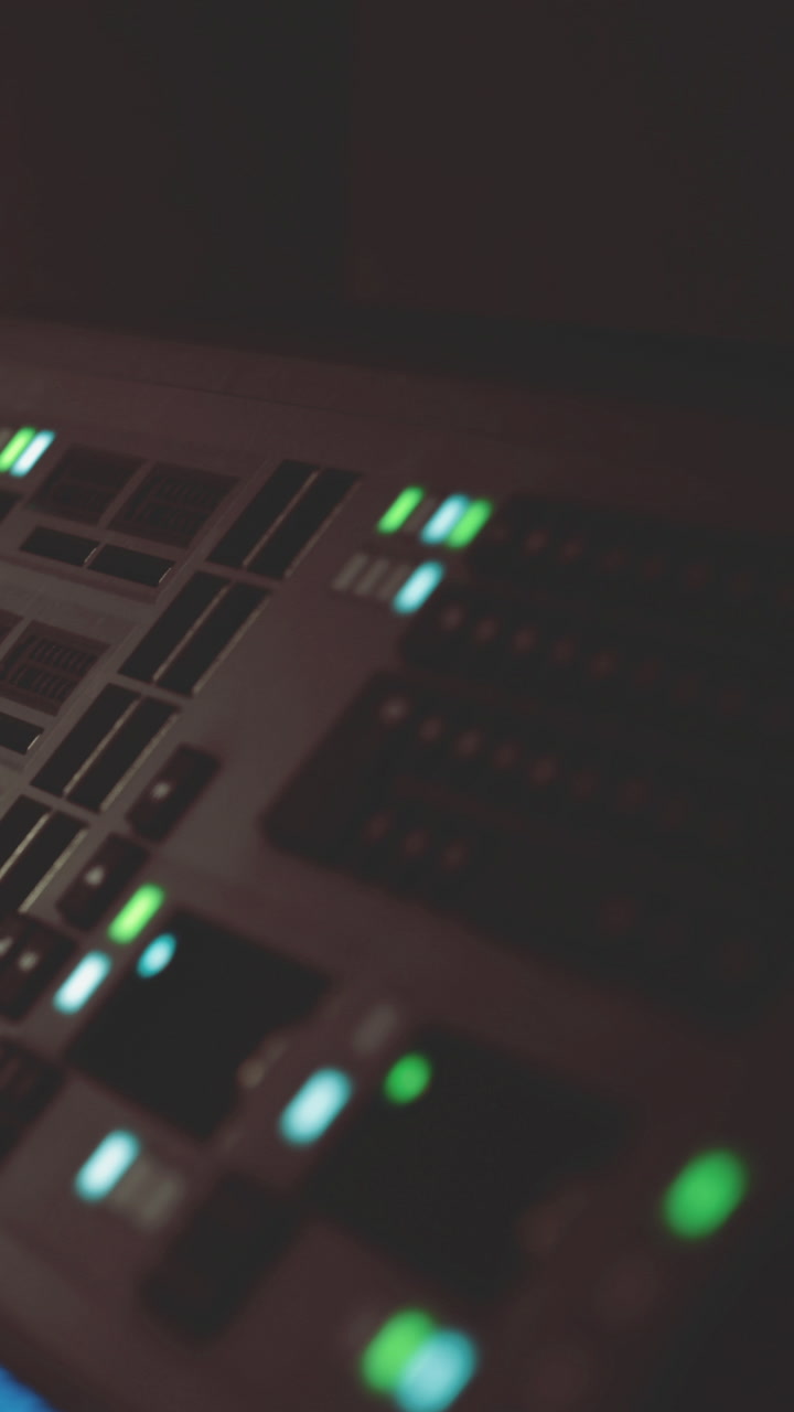 Control panel lights brighten a creative sound studio at night