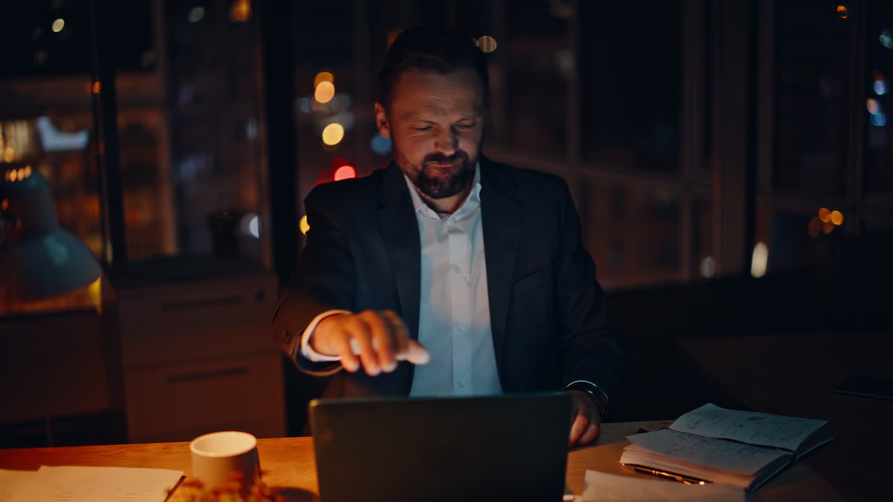 Frustrated executive reacting failure at desk night. Mad employee hitting table