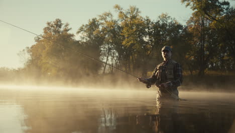 man fly fishing in a misty morning