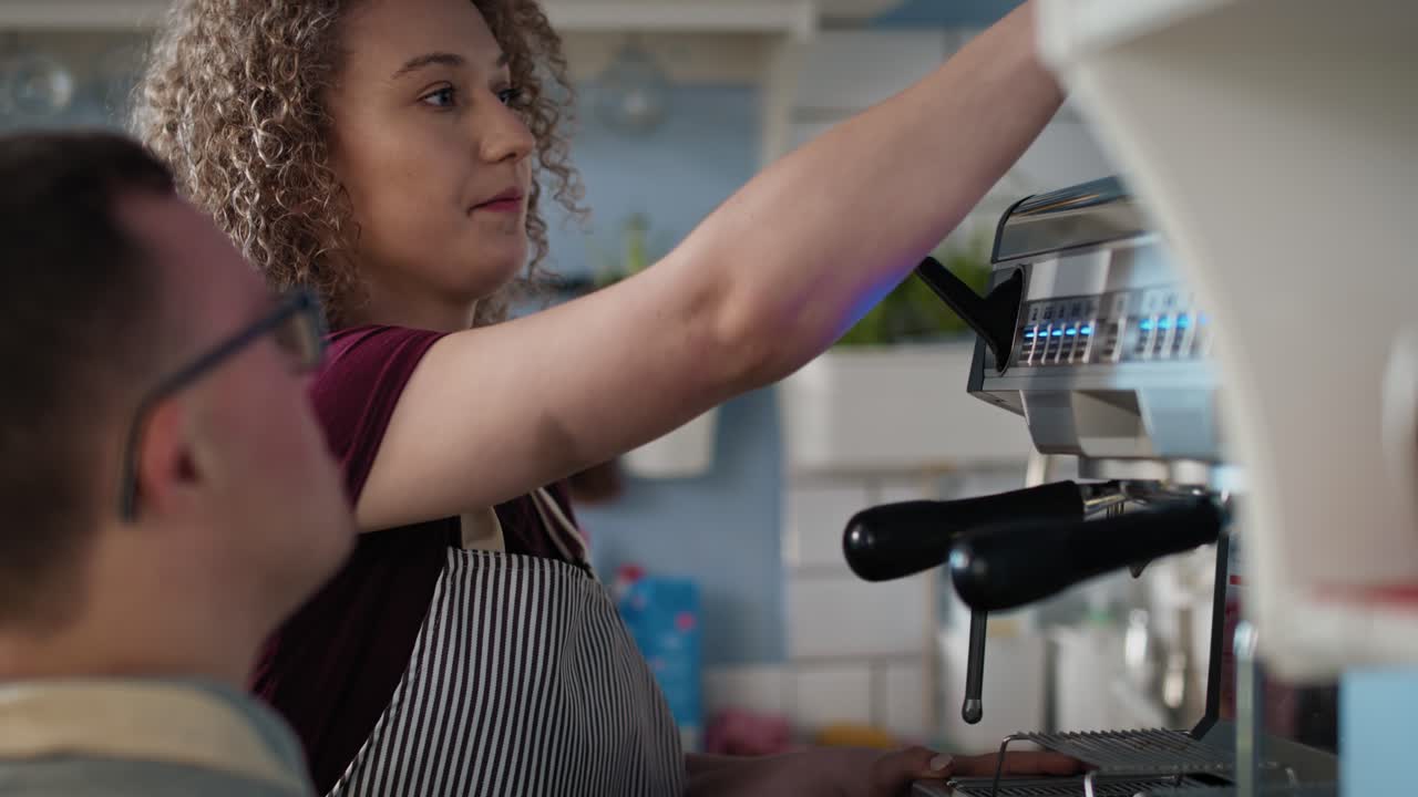 un hombre caucásico con síndrome de down ayudando a una camarera a hacer café.