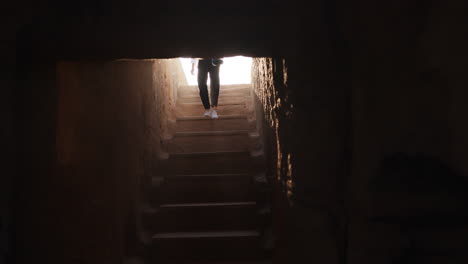 woman exploring ancient underground stairs