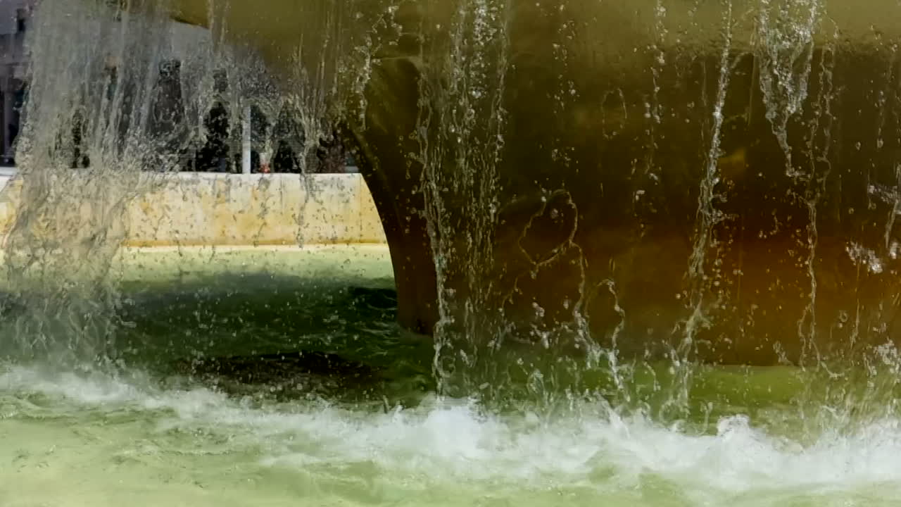 Una cortina d'acqua che si forma mentre i getti d'acqua cadono da una fontana nella piazza
