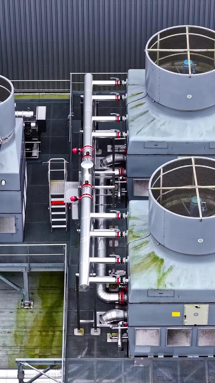 Grande sistema HVAC industriale con ventole di ventilazione che girano su un tetto in vista aerea verticale