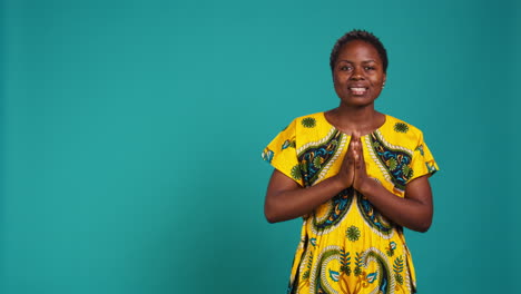 Optimistic-woman-praying-to-receive-something-in-studio