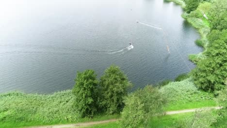 Drone-shot-over-nature-to-a-person-wakeboarding-at-water-sport-park